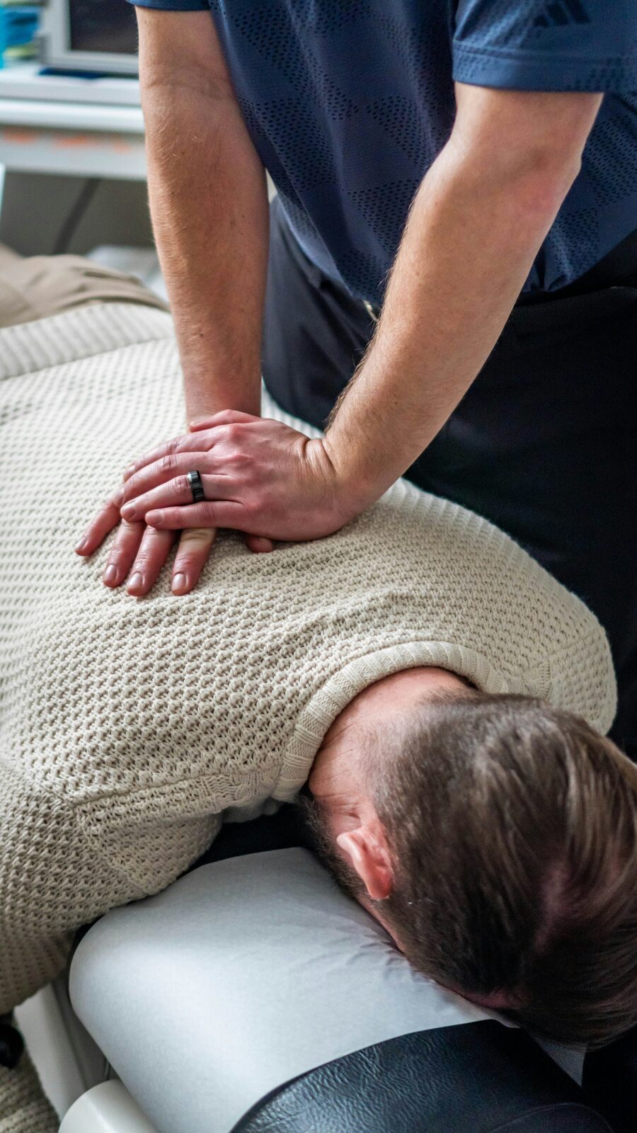 Chiropractor working with a person lying on a treatment table