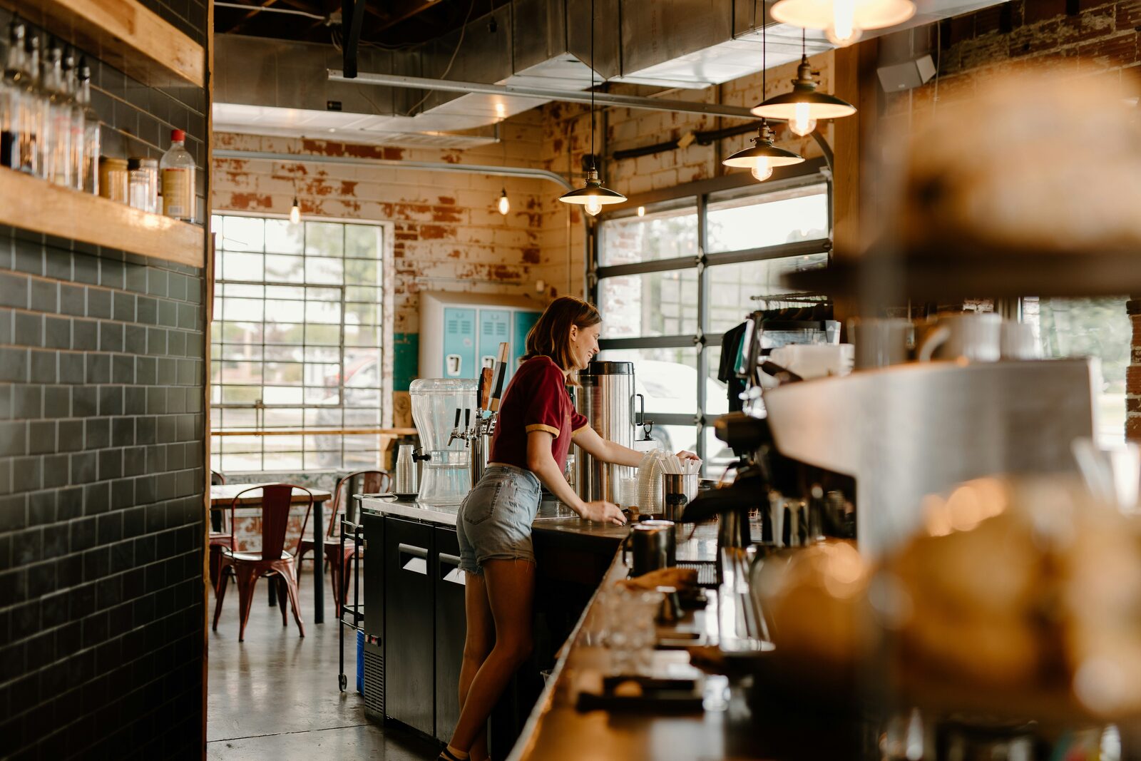 Barista working behind the counter in a warmly lit coffee shop