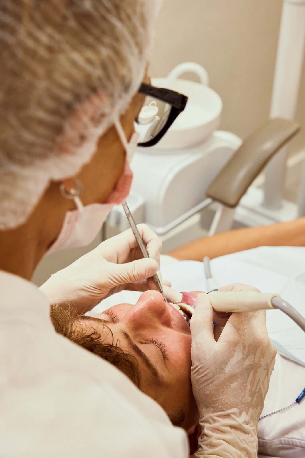Dental professional examining a person in a dental chair