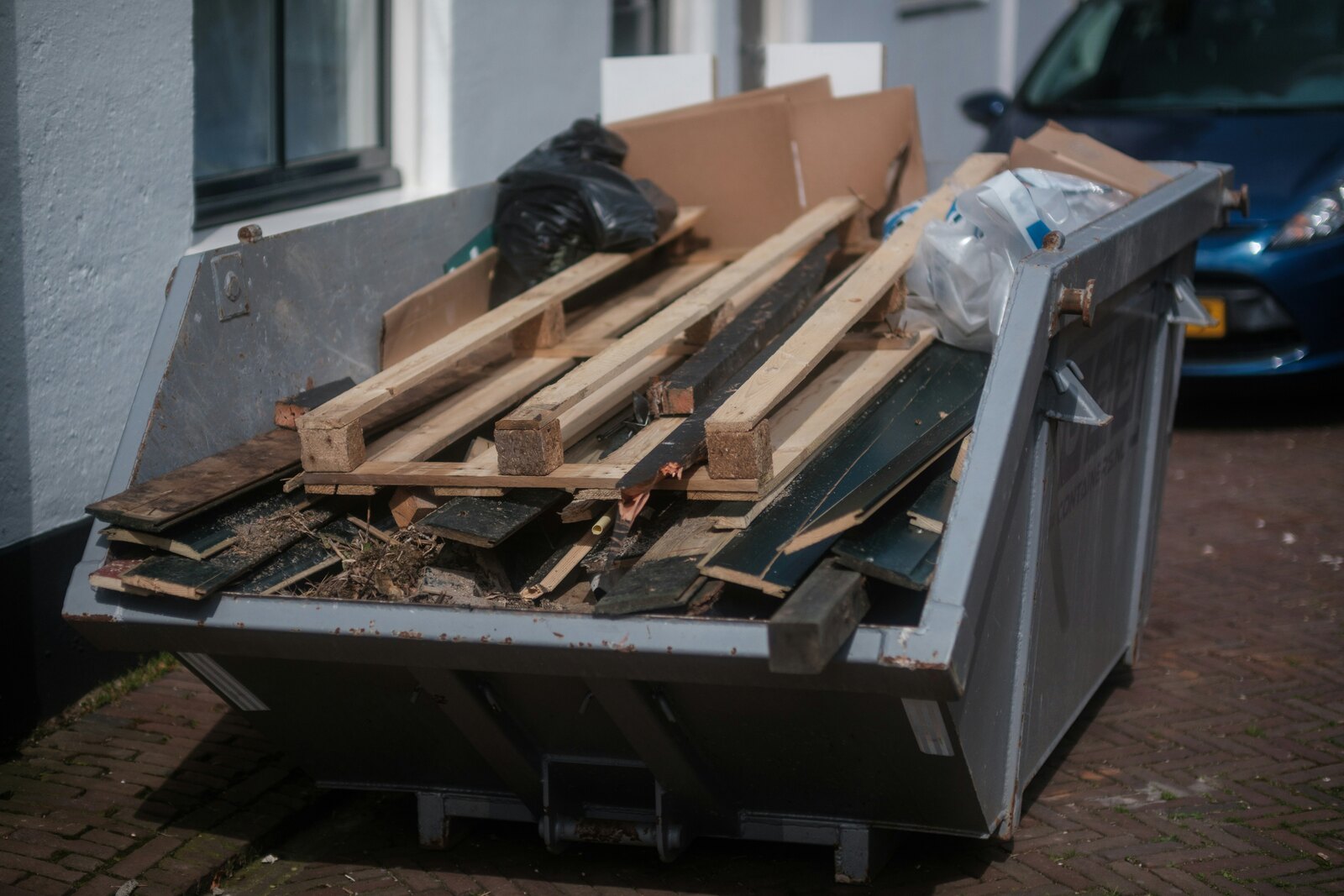 Skip filled with wood, cardboard and other debris ready for junk removal
