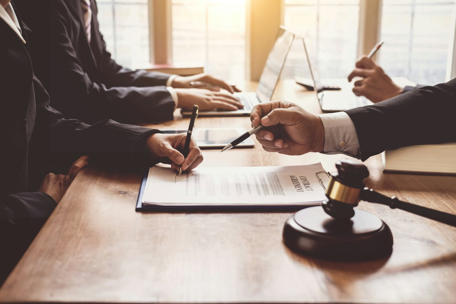Professionals reviewing a contract at a table with a gavel