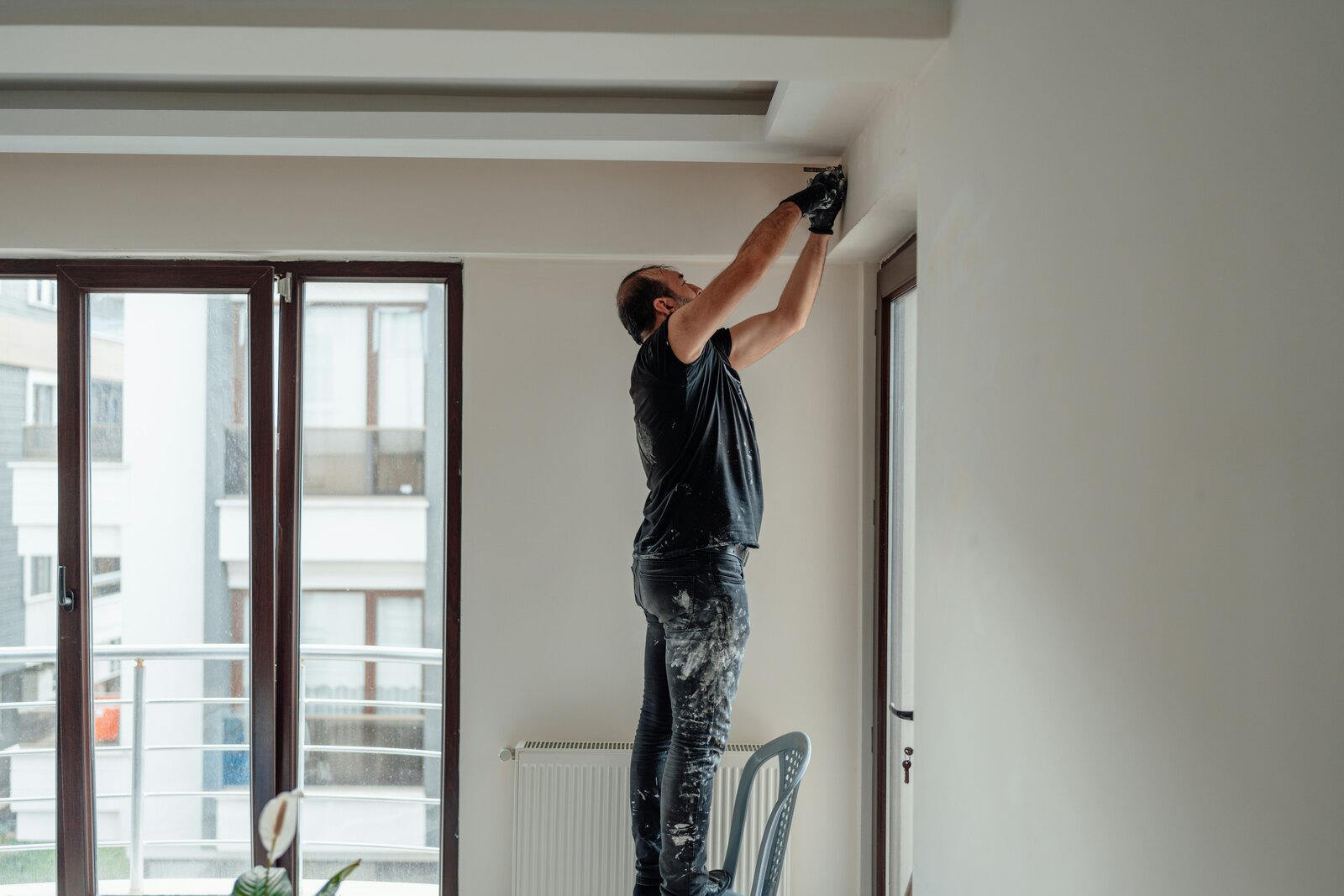 Painter working along the upper edge of an interior wall