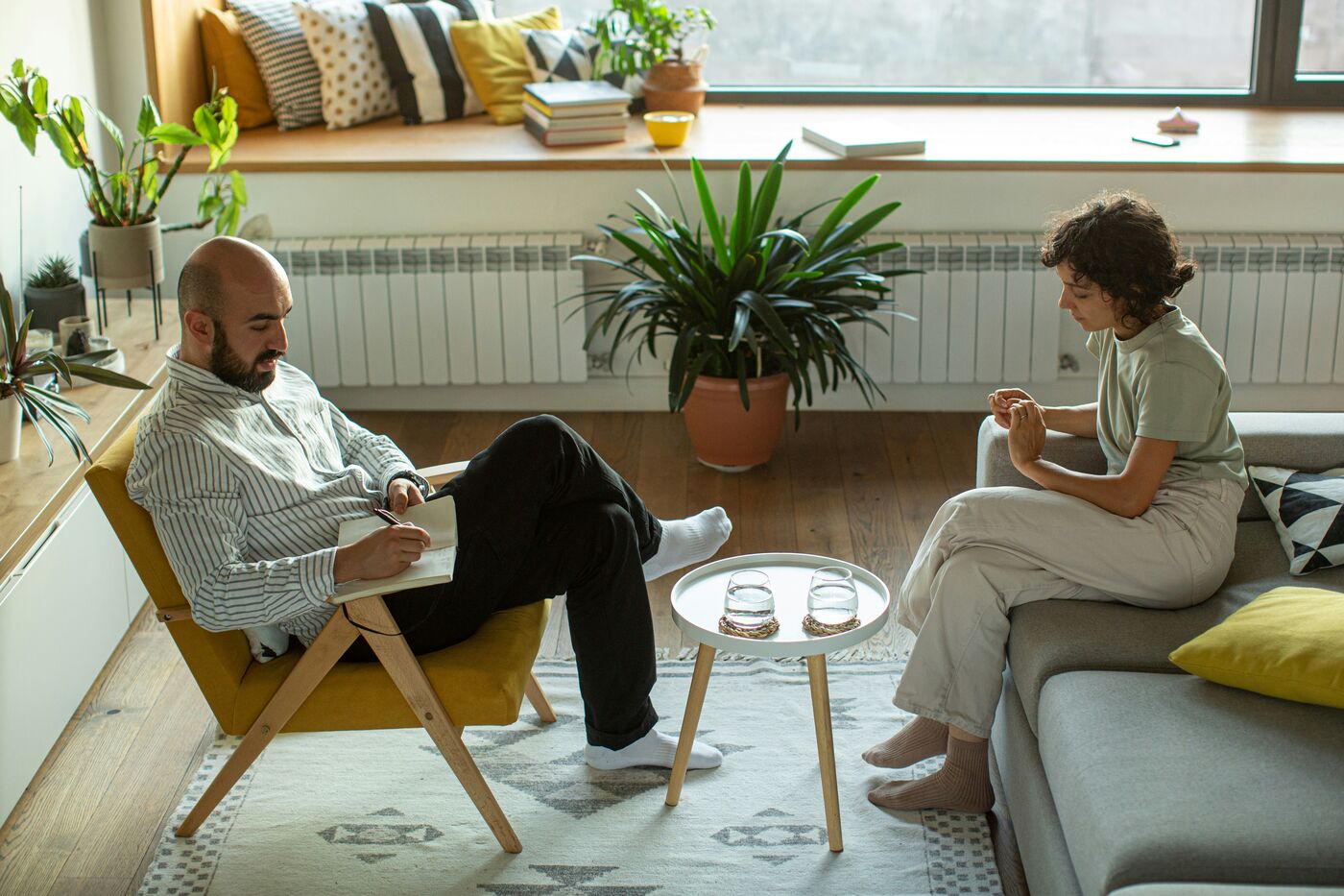 Counselor taking notes during a conversation in a comfortable office